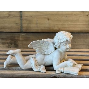 Engel figur ligger og lser en bog
