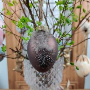 Matbrunt p�ske�g dekoreret med en lille naturfjer og snor til oph�ng.