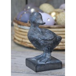 En naturtro �lling-figur i polyresin med antique kul finish, placeret foran en kurv med p�ske�g i st�rrelsen H12,5 cm.