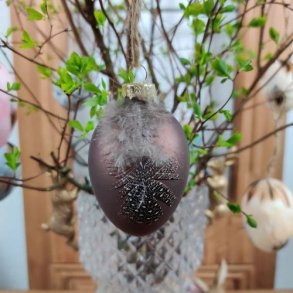 Matbrunt p�ske�g dekoreret med en lille naturfjer og snor til oph�ng.