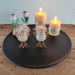 Dekorativ opstilling p� et sort fad med to p�skekyllinger, bloklys og sm� tulipanvaser som inspiration til p�skebordet.