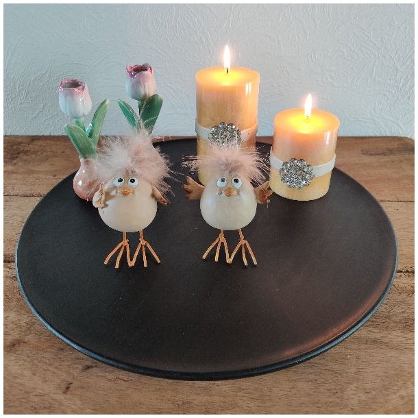 Dekorativ opstilling p� et sort fad med to p�skekyllinger, bloklys og sm� tulipanvaser som inspiration til p�skebordet.