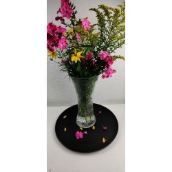 En stor, klar glasvase med krakeleret m�nster fyldt med vand og en sommerlig buket af lilla phlox og sm� gule blomster, placeret foran en hvid v�g med m�nstret tapet.