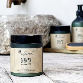 Eternel fodbadesalt opstillet i et badev�relsesmilj� ved siden af en stenvask, der illustrerer en luksuri�s spa-oplevelse.
