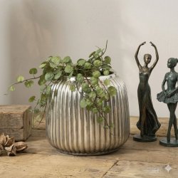 Keramikpotte-Antik-Soelv-Figurer S�lvfarvet rillet keramikpotte med en gr�n h�ngeplante, placeret p� et tr�bord ved siden af to balletfigurer.
