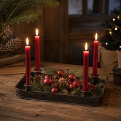 Rustikt adventsfad i m�rkt jern opstillet med r�de stagelys, gran, kogler og r�de julekugler i et hyggeligt milj�.