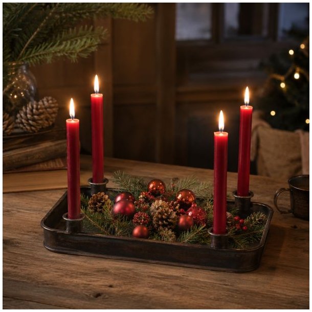 Rustikt adventsfad i m�rkt jern opstillet med r�de stagelys, gran, kogler og r�de julekugler i et hyggeligt milj�.