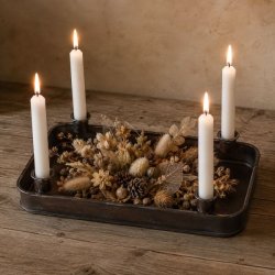 Adventsfad i m�rkt jern med fire lysholdere og hvide stagelys, pyntet med t�rrede blomster, korn og kogler p� et tr�bord.