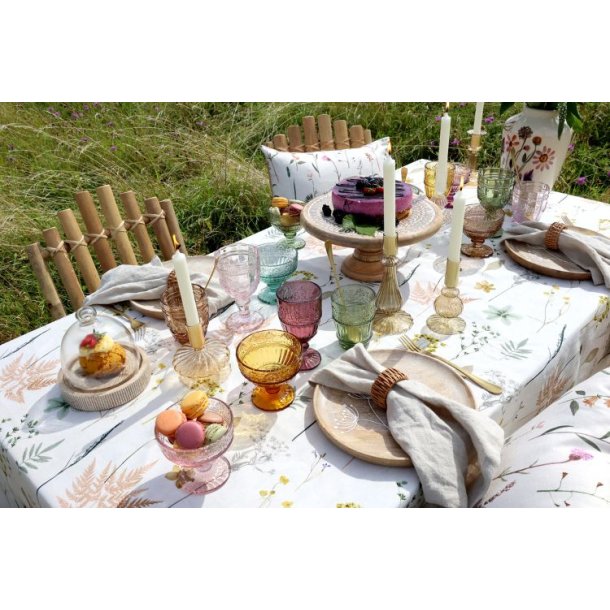 Et smukt d�kket sommerbord med de farvede Saint-�milion glas, hvide lys og blomster i det fri.