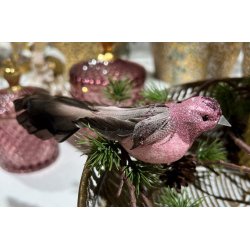 Rosabrun dekorationsfugl med glimmer og lange fjer placeret p� en grangren med dekorative rosa glasb�tter i baggrunden.