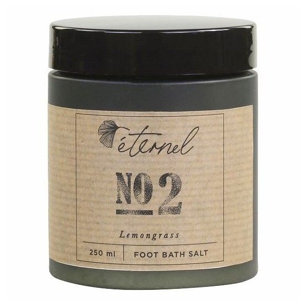 En m�rk krukke med Eternel Fodbadesalt No. 2 med citrongr�s p� 250 ml, vist p� en hvid baggrund.