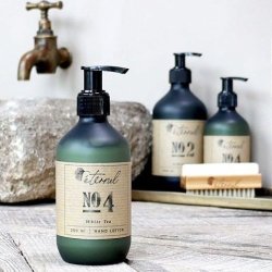 Eternel H�ndlotion No. 4 opstillet i et rustikt badev�relsesmilj� ved en vask, der fremh�ver produktets eksklusive design.