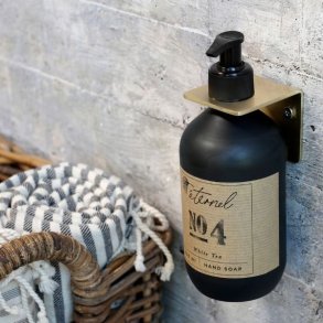 Milj�billede af det messing-farvede v�goph�ng monteret p� en v�g, der viser det elegante og funktionelle design til badev�relset.