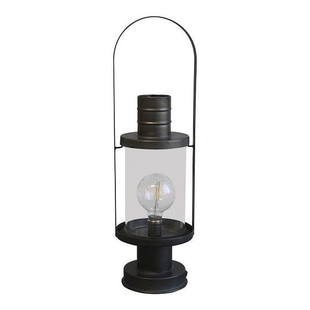 En fritlagt fransk staldlanterne i jern med antique kul-finish. Lanternen er 53 cm h�j og har en h�j, rund hank og en glascylinder, der beskytter den medf�lgende LED-p�re. Den st�r p� en stabil fod.