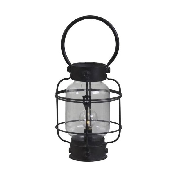 Fritlagt produktbillede p� hvid baggrund af den runde franske staldlanterne i antik sort metal, der m�ler H23 cm. Lanternen har et stort, rundt b�reh�ndtag og en t�ndt p�re indeni.