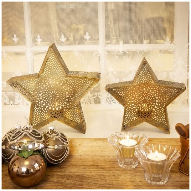 To m�nstrede julestjerner i antik guld metal som fyrfadsholdere placeret i en vindueskarm sammen med julekugler og glasstager.