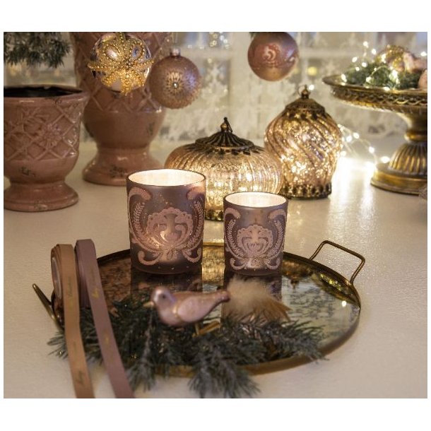 Mat rosa fyrfadsstage opstillet i et hyggeligt milj� med naturmaterialer og lys p� et tr�bord.