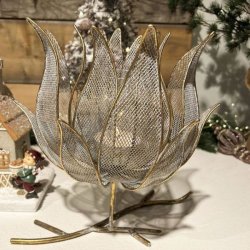Blomsterformet fyrfadsstage p� grenfod i antik guld metal opstillet i et hyggeligt julemilj�.