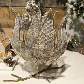 Blomsterformet fyrfadsstage p� grenfod i antik guld metal opstillet i et hyggeligt julemilj�.