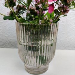 Champagnefarvet rillet glasvase anvendt som lille vase til en fin buket af sommerblomster.