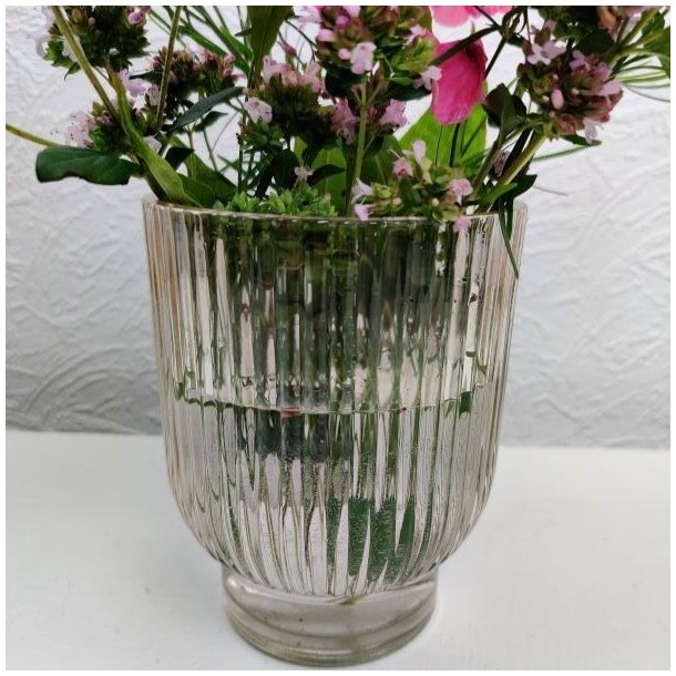 Champagnefarvet rillet glasvase anvendt som lille vase til en fin buket af sommerblomster.