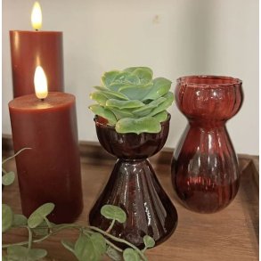 To bordeauxr�de glasvaser i forskellige st�rrelser brugt som hyacintglas og fyrfadsstage p� et bord