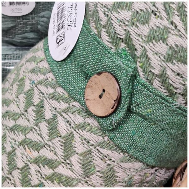 N�rbillede af det praktiske lukkeb�nd med knap, der holder den sammenrullede gr�nne bomuldsplaid p� plads.