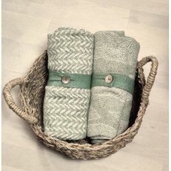 En sammenrullet gr�n plaid holdt p� plads af et praktisk b�nd med knap, klar til transport.