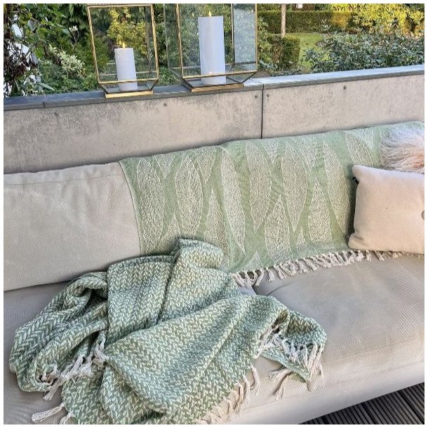 Milj�billede af de gr�nne plaider i brug udend�rs, hvilket viser deres anvendelighed til fritid og have.