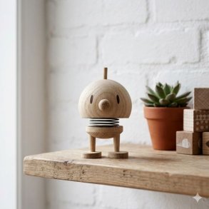 Et n�rbillede af en klassisk Hoptimist Bumble hoptimist baby i ubehandlet egetr�, der st�r alene p� en rustik tr�hylde. Baggrunden er en struktureret, hvidmalet murstensv�g, og bl�dt naturligt lys oplyser figuren.