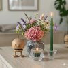 En hyggelig opstilling p� en lys tr�sk�nk med en Hoptimist-figur i egetr�, en vase med hortensia og lavendel, samt t�ndte stearinlys i glasstager.