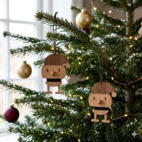 7028-01-hoptimist-julemand-trae.jpg Et firkantet 1:1 milj�billede af et Santa ornament s�t fra Hoptimist, hvor 2 stk. julem�nd i m�rk egetr� med en h�jde p� 12,5 cm h�nger i brune snore ved siden af hinanden p� de gr�nne grene af et juletr� pyntet med d�mpede, varme julelys.