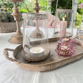 Milj�billede af den h�je sandfarvede hurricane lysestage med et t�ndt lys, placeret i en hyggelig indretning.