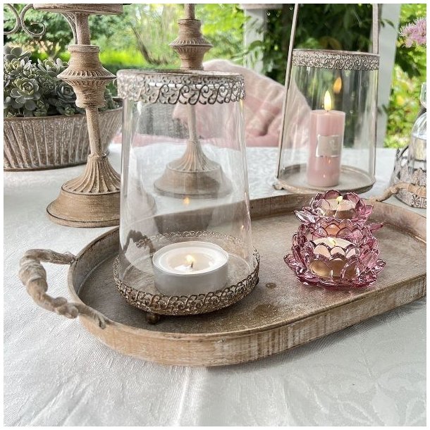 Milj�billede af den h�je sandfarvede hurricane lysestage med et t�ndt lys, placeret i en hyggelig indretning.