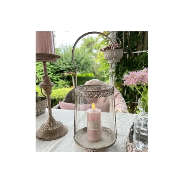 Milj�billede af den sandfarvede hurricane lysestage med hank, placeret i en hyggelig indretning med et t�ndt bloklys.