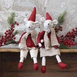 Stemningsfuldt milj�billede af to siddende julemus i r�d polyester placeret p� en tr�kasse omgivet af grangrene og r�de b�r.