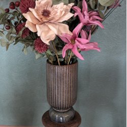 Et fokuseret billede af keramikvasens rillede m�nster, der tydeligt viser den rustikke tekstur og de m�rkebrune farvespil i materialet.