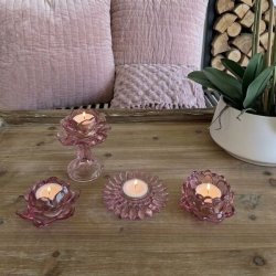 Fire forskellige rosa fyrfadsstager i farvet glas fra La Vida med t�ndte lys opstillet p� et tr�bord.