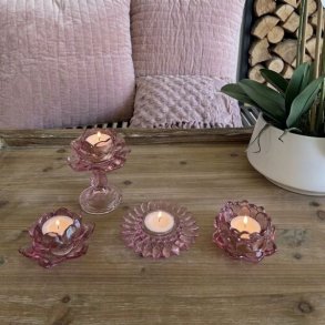 Fire forskellige rosa fyrfadsstager i farvet glas fra La Vida med t�ndte lys opstillet p� et tr�bord.