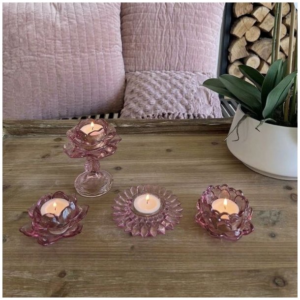 Fire forskellige rosa fyrfadsstager i farvet glas fra La Vida med t�ndte lys opstillet p� et tr�bord.