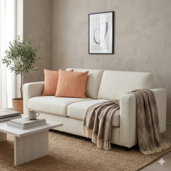 la-vida-stuemiljoe-boucle-sofa-puder-plaid Et lyst og moderne stuemilj�, hvor en bl�d, m�nstret plaid i st�vede brune og beige nuancer med lange frynser ligger hen over arml�net p� en hvid boucl�sofa. P� sofaen ses to matchende ferskenfarvede pyntepuder med struktur, og i baggrunden anes et lille oliventr� samt en enkel plakat p� den r�, lysegr� v�g.