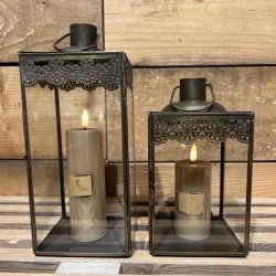 Den lille og store antikbrune lanterne opstillet indend�rs p� en tr�overflade med hyggelige, t�ndte LED-bloklys indeni.