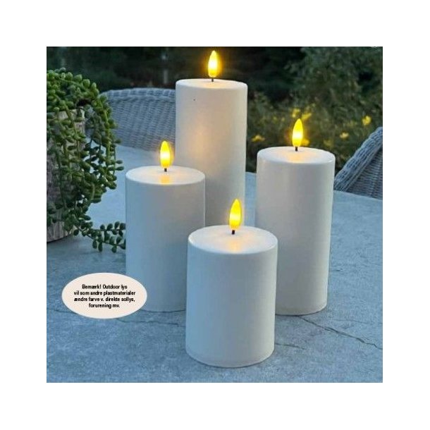 Et lille hvidt udend�rs LED-bloklys med varm flamme placeret p� et havebord.