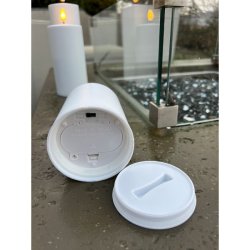 N�rbillede af bunden p� et hvidt udend�rs LED-bloklys, der viser det forseglede batterid�ksel og t�nd/sluk-knappen med timerfunktion.