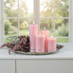 Milj�billede af alle fire rosa LED-bloklys i forskellige h�jder arrangeret p� en dekorativ s�lvbakke med lilla blomster foran et lyst vindue.