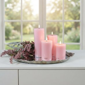 Milj�billede af alle fire rosa LED-bloklys i forskellige h�jder arrangeret p� en dekorativ s�lvbakke med lilla blomster foran et lyst vindue.