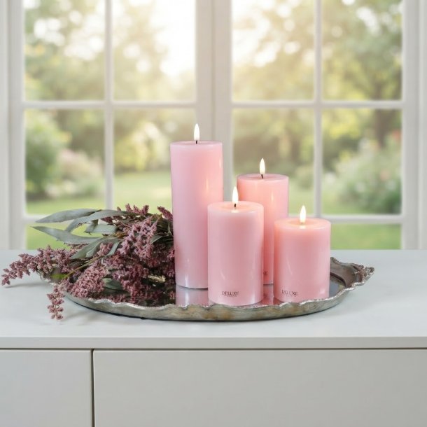 Milj�billede af alle fire rosa LED-bloklys i forskellige h�jder arrangeret p� en dekorativ s�lvbakke med lilla blomster foran et lyst vindue.
