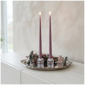 Stemningsfuldt milj�billede af t�ndte lilla LED-kertelys fra La Vida i glasstager p� en spejlbakke med pyntefigurer og blomsterdetaljer p� en hvid sk�nk.
