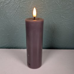 N�rbillede af det t�ndte mokkabrune LED-bloklys med 3D statisk real flamme st�ende p� en lys overflade foran en gr�nlig, struktureret v�g.