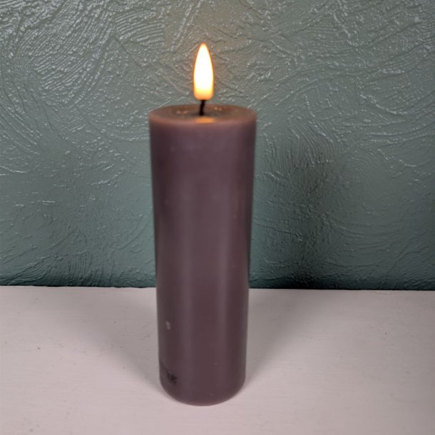 N�rbillede af det t�ndte mokkabrune LED-bloklys med 3D statisk real flamme st�ende p� en lys overflade foran en gr�nlig, struktureret v�g.